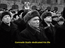 a black and white photo of a crowd with a caption that says " comrade stalin dedicated his life "