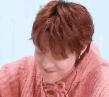 a close up of a person wearing a pink sweater .