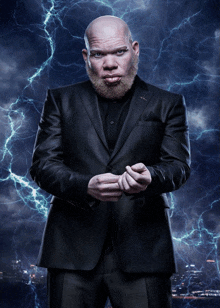 a bald man with a beard is wearing a black suit and black shirt