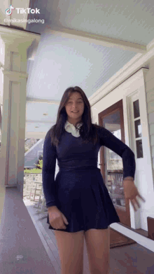 a girl in a blue dress is standing on a porch with a tiktok watermark