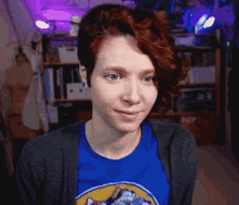 a woman with red hair is wearing a blue shirt that says nintendo