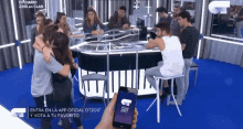 a group of people are gathered around a table and a person is holding a phone that says ot2017