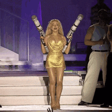 a woman in a gold dress holds a pair of cigarettes over her shoulder