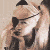 a close up of a woman wearing a bandage on her eye and a ponytail .