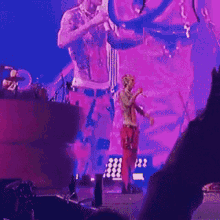 a man is singing into a microphone while playing a guitar on a stage .