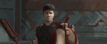 a man is holding a shield and a spear in his hand