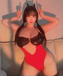a woman in a red bodysuit with horns on her head is giving the middle finger