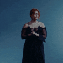 a woman with red hair is wearing a black dress