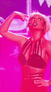 a woman in a black bra is dancing on a stage