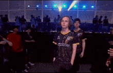 a man wearing a gaming gg jersey walks through a crowd