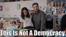 a man and a woman in a kitchen with the words " this is not a democracy "