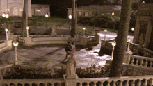 a couple dancing in a courtyard at night