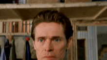 a close up of a man 's face with a serious look on his face in a room .