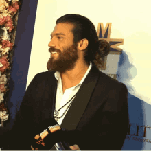 a man with a beard is smiling in front of a sign that says lit