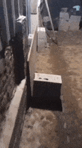 a concrete block is sitting on the ground next to a brick wall
