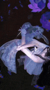 a painting of a woman in a white dress with purple flowers in the background