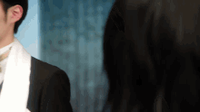 a man in a suit and tie is looking at another man