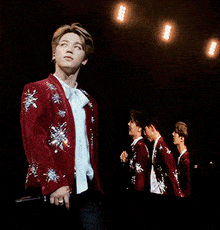 a young man in a red jacket with silver stars on it