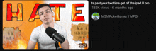 a man in a white shirt stands in front of a microphone with the word hate written above him