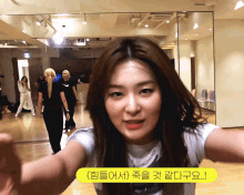 a woman taking a selfie in front of a mirror with a yellow sticker that says ' korean ' on it