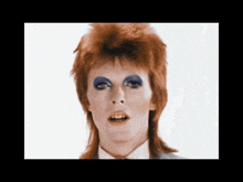 a close up of david bowie 's face with blue eye shadow