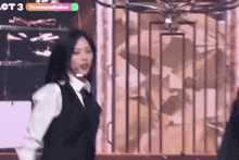 a woman is dancing on a stage in front of a cage .