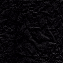 a crumpled piece of black paper with a white cross in the middle