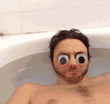 a man in a bathtub with big googly eyes