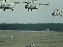 a group of helicopters flying over a field