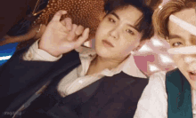 a man in a suit is making a peace sign next to another man in a white shirt .