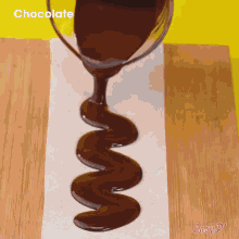 a swirl of chocolate is being poured into a piece of wax paper