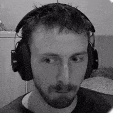 a black and white photo of a man wearing headphones .