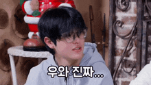 a man wearing glasses and a hoodie says something in a foreign language