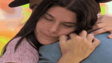 a woman hugging a man with her eyes closed and smiling
