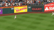 a baseball field with giant and w.b.mason ads