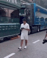 a man walking down a street in front of a truck that has the word alpine on it