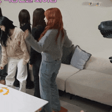a group of women standing in front of a couch with a pink sticker that says " hol "