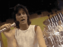 a man sings into a microphone in front of a drum set