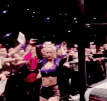 a woman is dancing in front of a crowd of people .