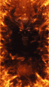 a devil with horns and red eyes is surrounded by fire .