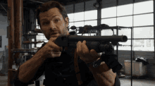 a man is holding a shotgun in a room