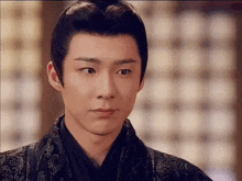 a close up of a man 's face with a traditional hairstyle