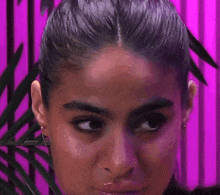 a close up of a woman 's face in front of a pink background