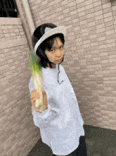 a person wearing a helmet and holding a bunch of green onions
