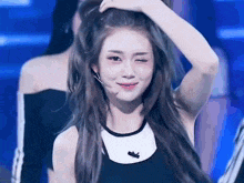 a woman with long hair is making a funny face while holding her hair .