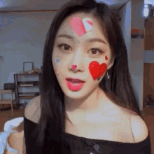 a woman with hearts painted on her face is standing in a room .