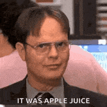 a man in a suit and tie is talking about apple juice .