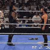 two wrestlers are standing in a wrestling ring and one of them has a shirt that says smack down on it