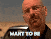 a man with glasses and a beard says " want to be " in front of a car