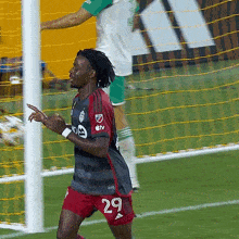 a soccer player with the number 29 on his shorts celebrates a goal
